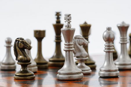 Tabuleiro de xadrez de madeira com peças de metal. xeque-mate