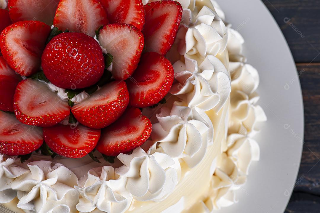 Bolo de aniversário lindo coberto com chantilly e palha fresca JPG