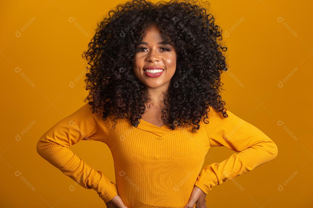 Uma menina com cabelos cacheados está sorrindo para a câmera