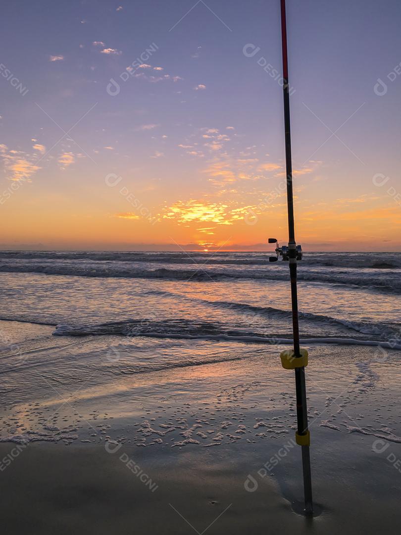 Fishing rod on the beach at sunset, surf cast.