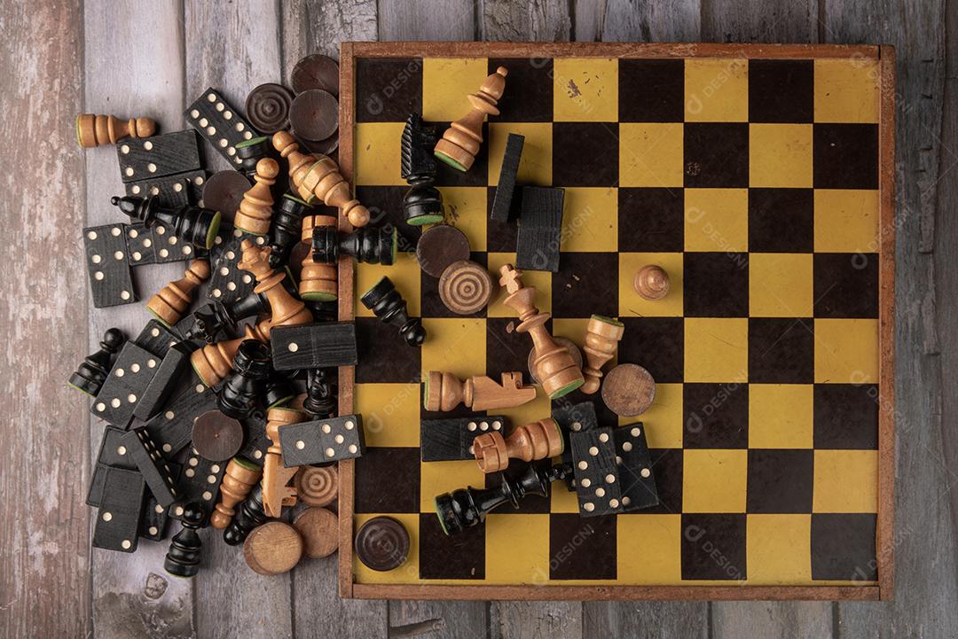 Jogo de damas no tabuleiro de damas em fundo de madeira.