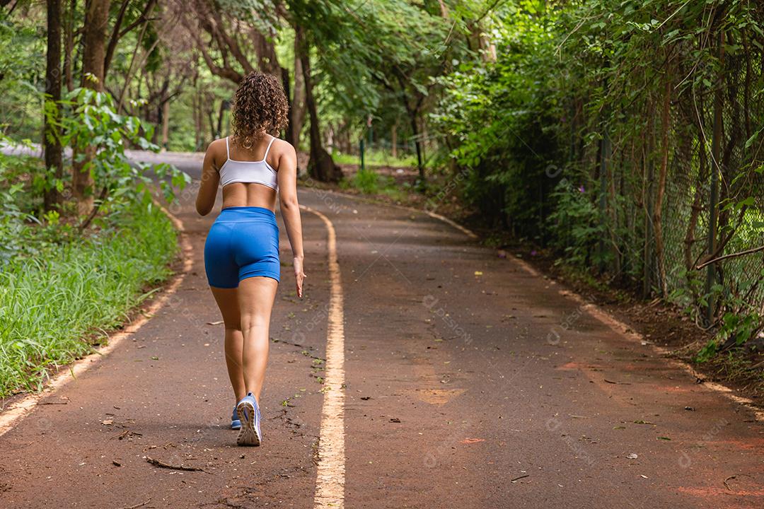 Mulher adulta jovem em roupas esportivas correndo no parque ao ar livre,  mulher corredor correndo na