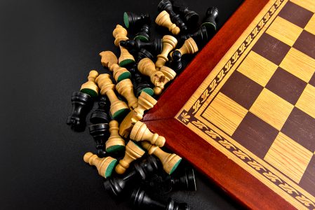 Peças de madeira brancas em um tabuleiro de xadrez um tabuleiro de xadrez  configurado durante um jogo em um fundo preto
