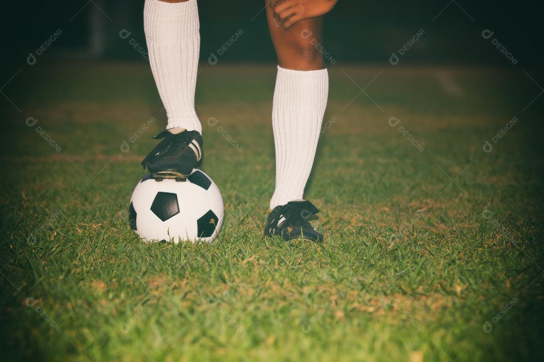 jogador de futebol ou futebol em pé com bola no campo para chutar a