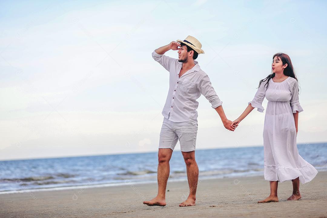 Happy lover romantic couple holding hands walking on the beach