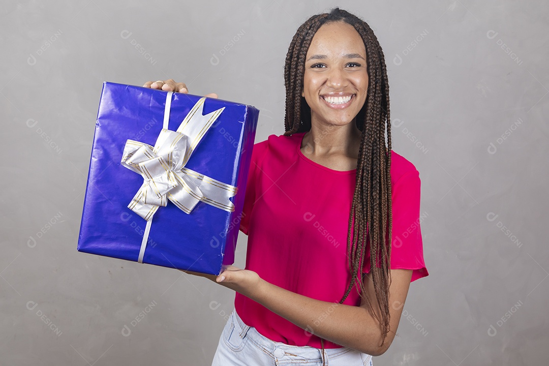 Linda mulher jovem garota sorridente segurando presente sobre fundo isolado cinza