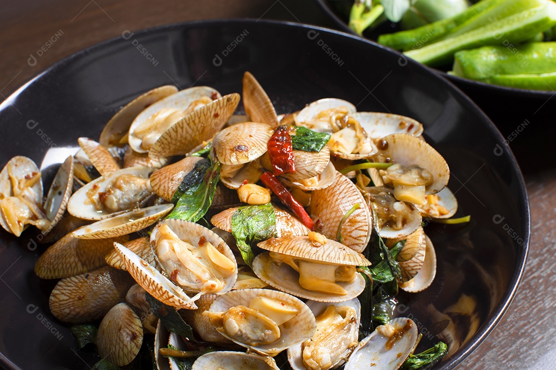 Close-up of fried clams with roasted pepper paste in a plate on wooden table