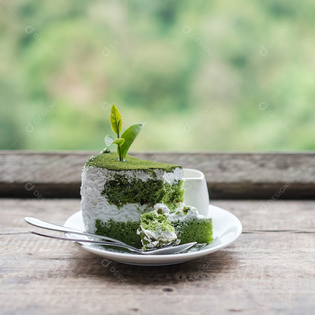 Green tea cake with young bud tea leaf on wooden table contra