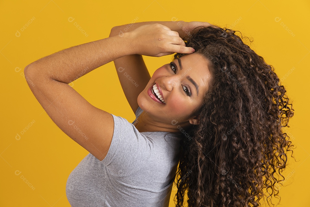 Linda mulher jovem morena cabelo cacheado sobre fundo isolado amarelo  [download] - Designi