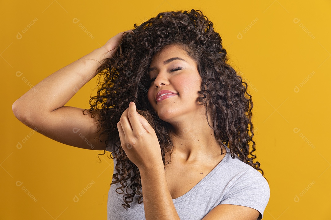 Linda mulher jovem morena cabelo cacheado sobre fundo isolado amarelo  [download] - Designi