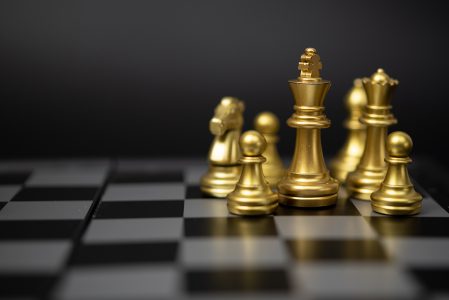 Homem de negócios tocando lâmpada no tabuleiro de xadrez com ideia de  negócio de peças de xadrez douradas e prateadas e conceito de estratégia