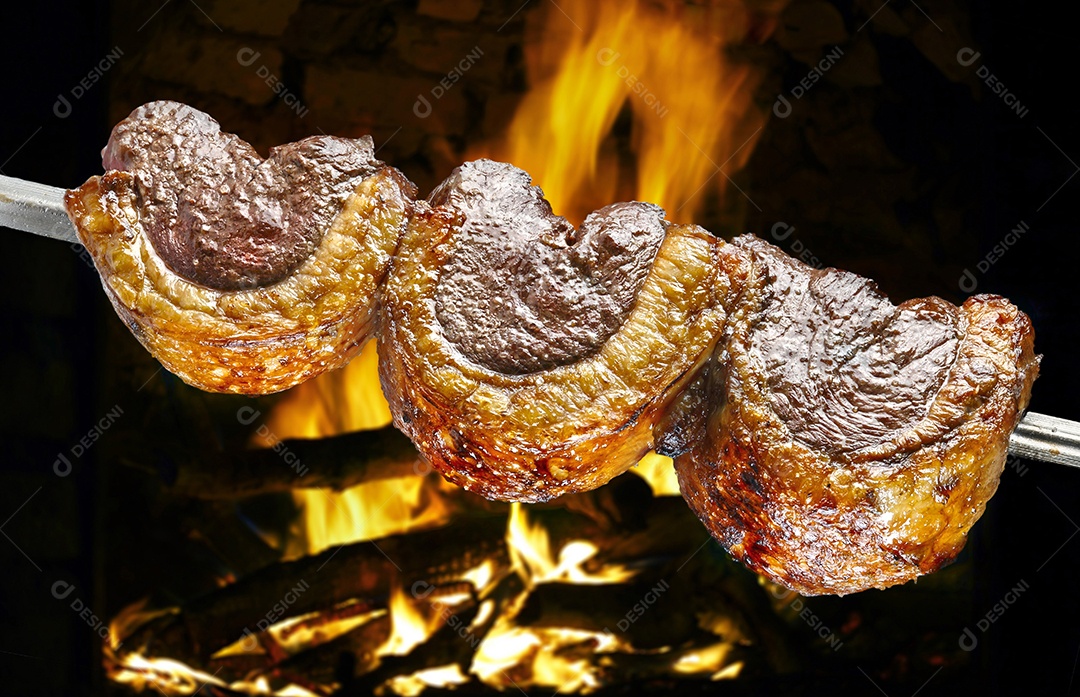 Churrasco de picanha assada no espeto na brasa. Esse tipo de churrasco é  amplamente consumido em todo o Brasil [download] - Designi