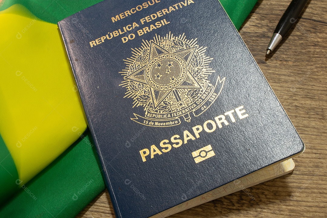 Passaporte brasileiro sobre bandeira do brasil e caneta