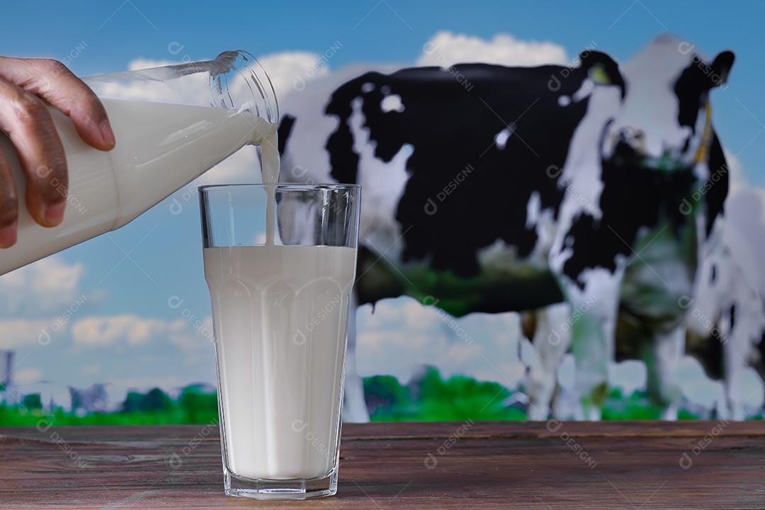 Bottle of milk and hand putting in a glass