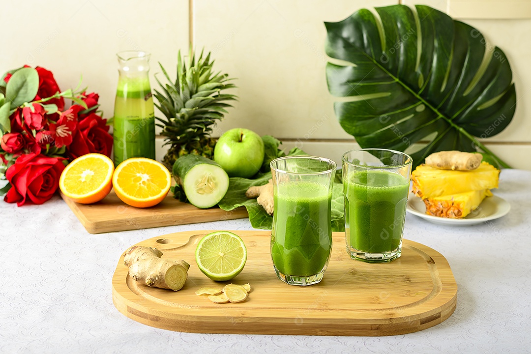 Copos com suco verde  sobre tábua de madeira