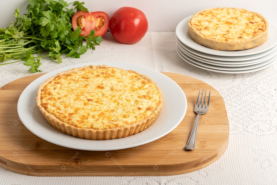 Quiche de queijo mão cortando fatia com fundo de ingredientes